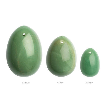 La Gemmes jade yoni egg set featuring three smooth, natural stones in varying sizes on a soft surface.