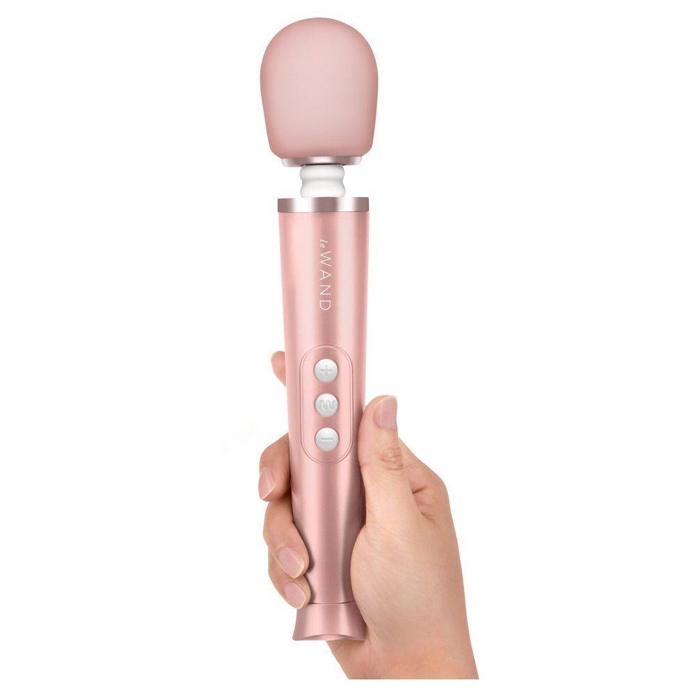 Le Wand Petite Gold rechargeable travel wand with a sleek design and ergonomic handle against a soft background.