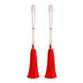 Red tassel nipple clamps by NS Novelties, featuring adjustable tension and a stylish, playful design.