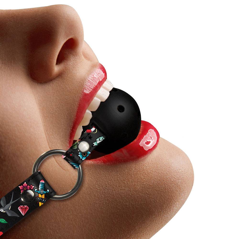 Shots Toys Ouch breathable ball gag with printed leather straps in black, showcasing its unique design and texture.