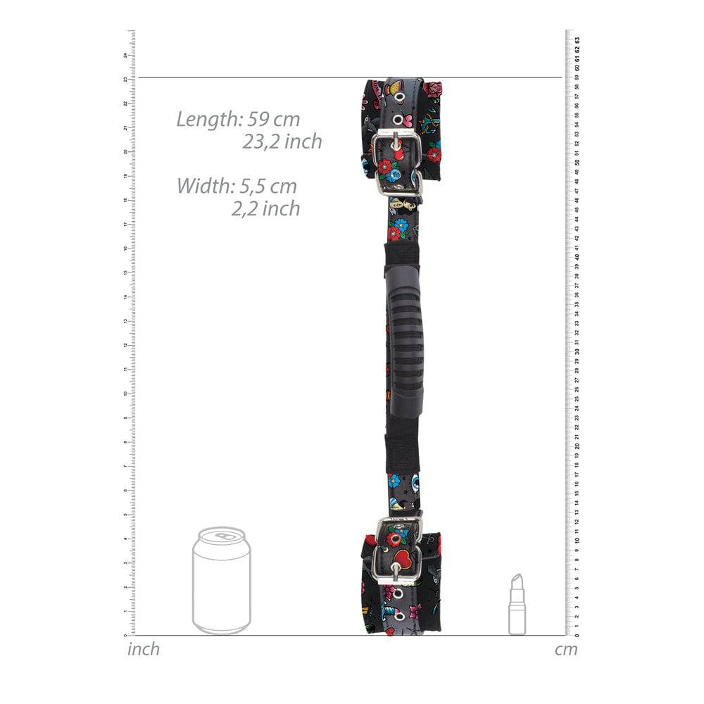 Shots Toys Ouch Old School Tattoo handcuffs with printed design and sturdy handles against a neutral background.