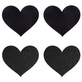 Black heart-shaped Peekaboos pasties on a soft surface, featuring a smooth finish and elegant design.